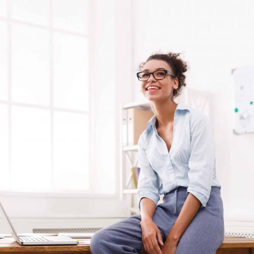 Meet Teshia Businesswoman in modern office. Happy smiling woman working on laptop at office, copy space