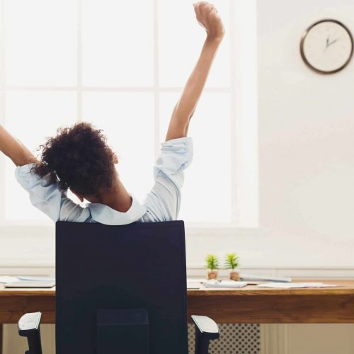 Business woman resting in office, back view Young african-american business woman rest, stretching on office chair, copy space, back view